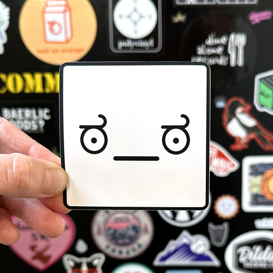 Look of disapproval sticker being held with a sticker door in the background