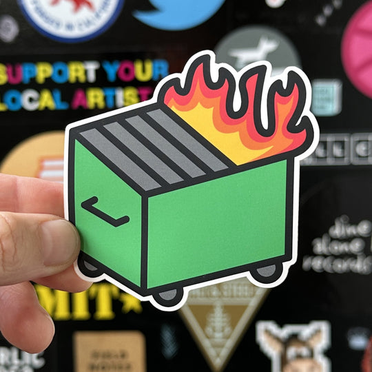 Dumpster fire sticker being held with a sticker door in the background
